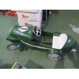 A child's green painted metal pedal racing car