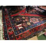 An Iranian wool blue ground rug, central diamond lozenge, fringing,