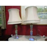 A pair of cut glass table lamps with cream shades,