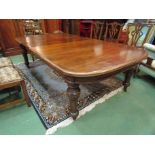 A late Victorian oak wind-out dining table with two extra leaves, heavy facet legs,