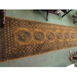 A mustard ground runner rug with multiple borders, tasselled ends and seven gulls,