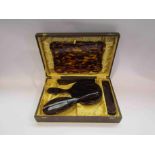 A cased tortoiseshell dressing set,