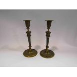 A pair of early 19th Century gilt candlesticks,