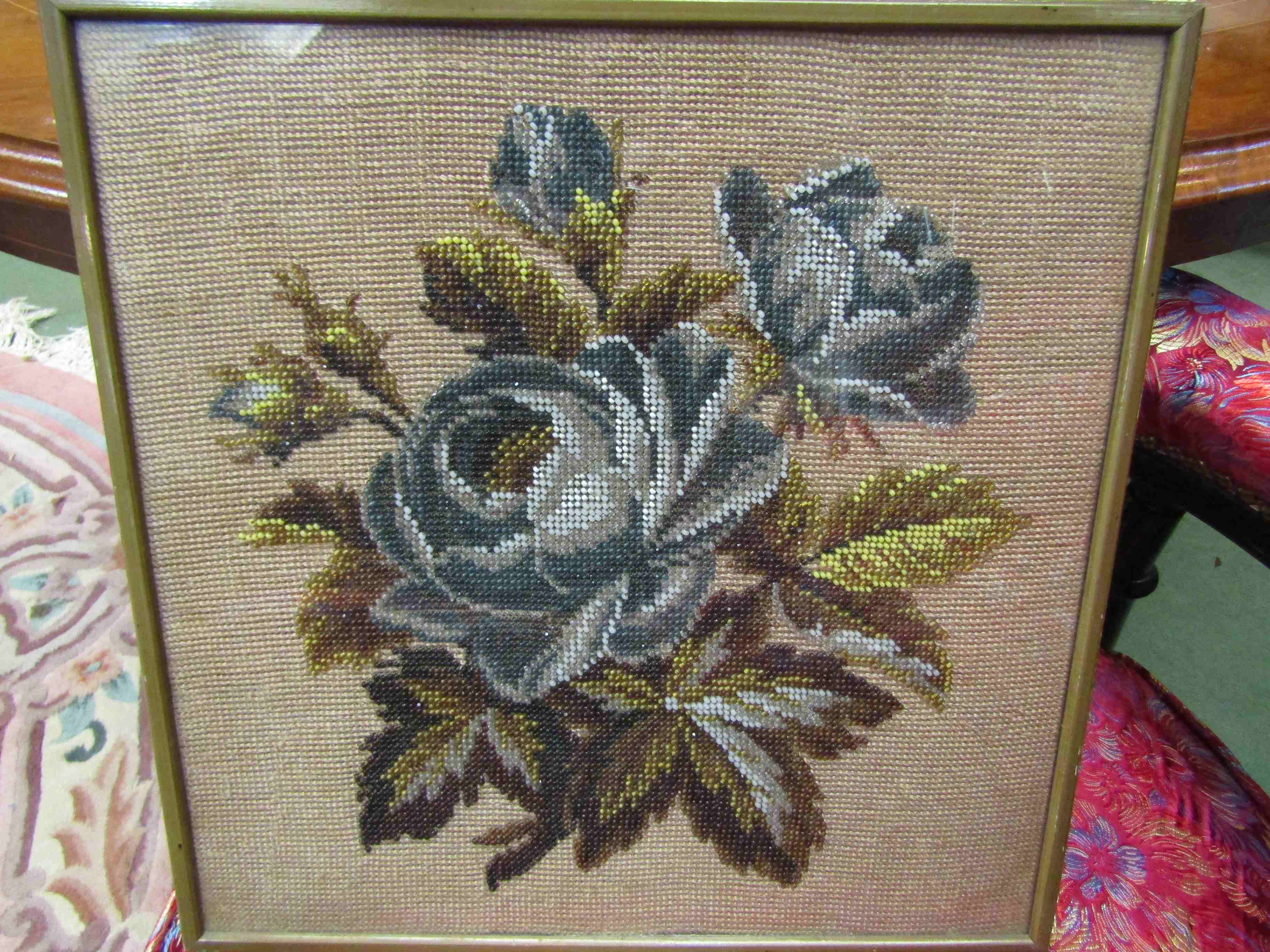 A beadwork picture of floral specimens,