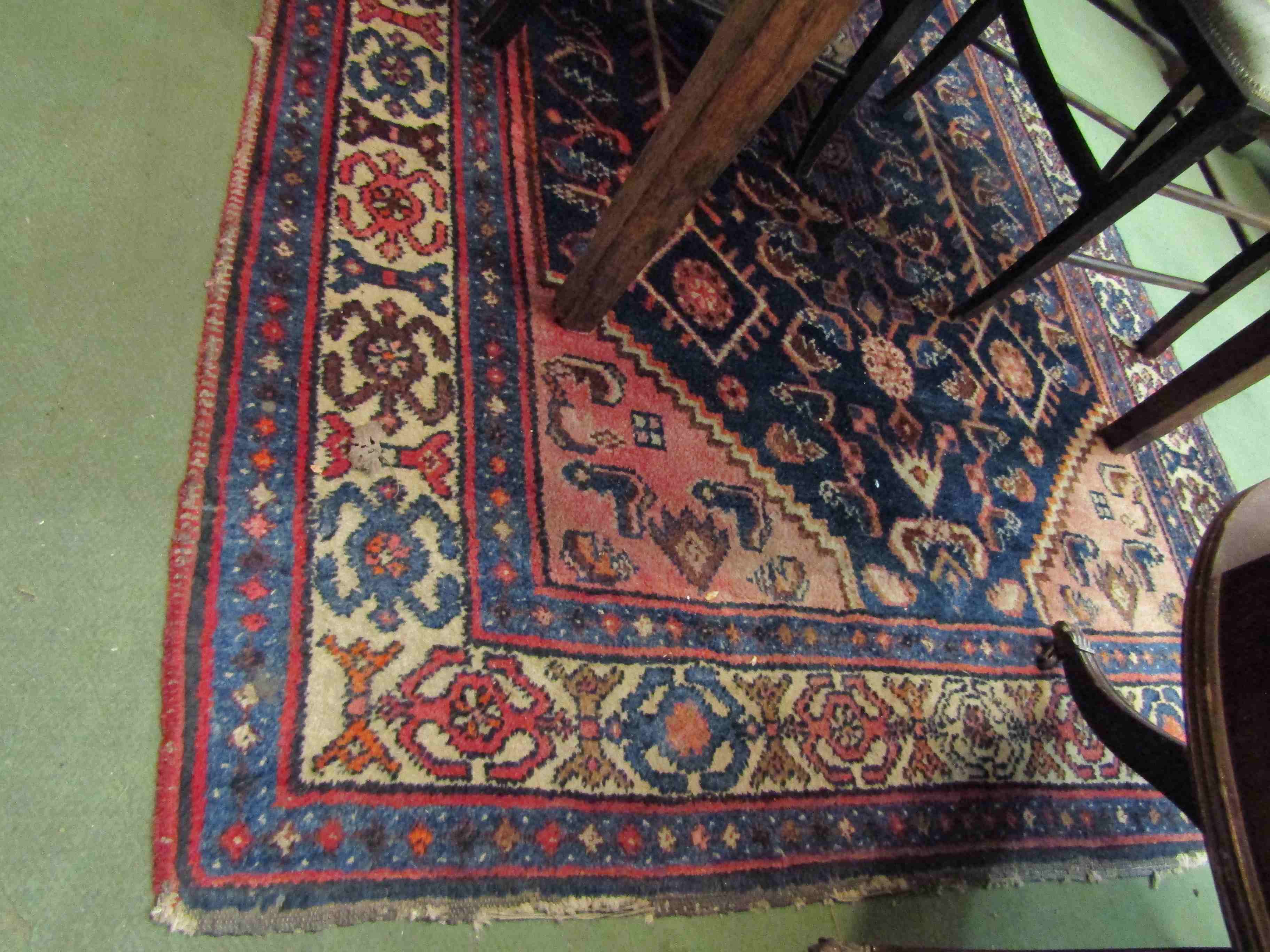 An Eastern wool rug. Blue ground with multiple borders and central stylised motifs.