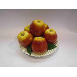 A Majolica style ceramic table centrepiece of apples in a lattice basket