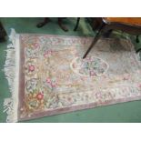 A Chinese mauve floral rug with tasselled ends,