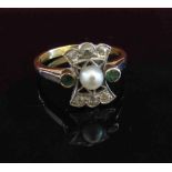 A gold ring with central set pearl flanked by emeralds and three diamonds to north-south,