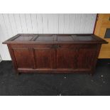 An 18th Century oak four panel hall coffer the hinged lid over turned stile feet,