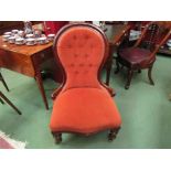 A Victorian walnut buttoned spoon back armchair over a serpentine front seat on turned legs and