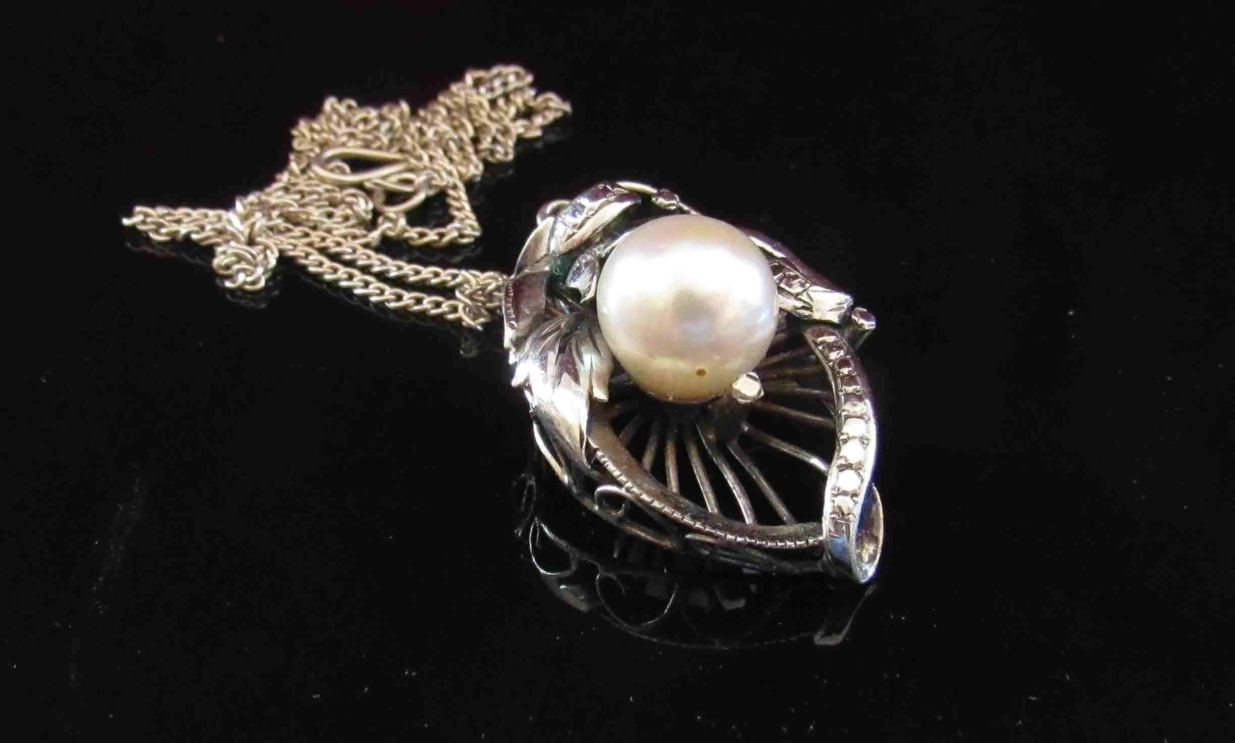 A white gold pendant/brooch set with single pearl, 8mm, unmarked 3.5cm drop, hung on chain, 5.