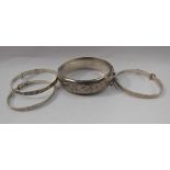 A silver wax filled engraved stiff hinge bangle,