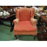 A wingback armchair on cabriole legs,