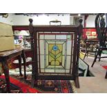 A mahogany fire screen with lead and glass floral panel, turned spindles,