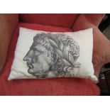 A cushion with images of Romans wearing laurel wreaths