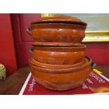 Three graduating terracotta lidded cooking pots