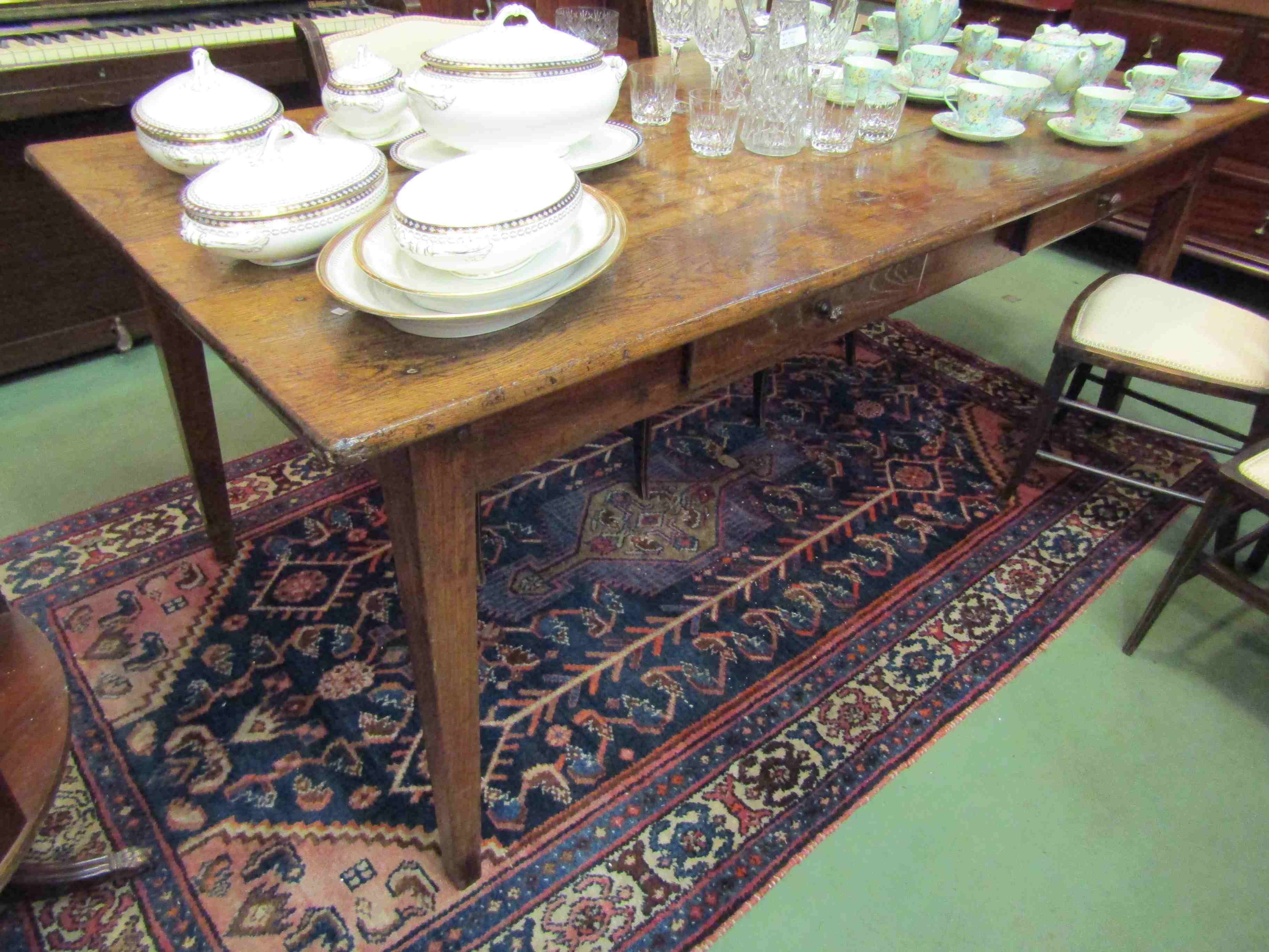 A French oak dining table with two drawers,