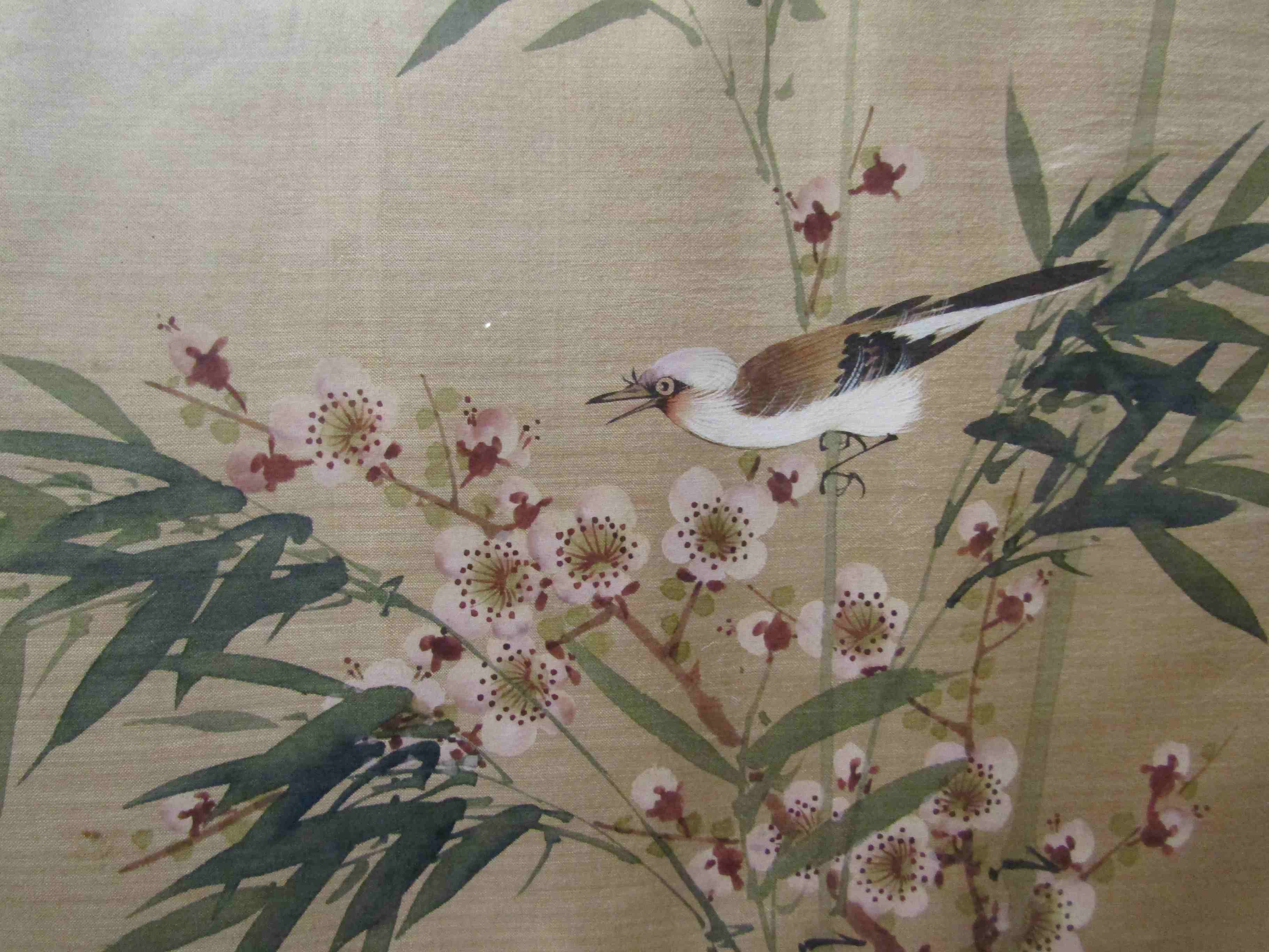 A framed and glazed painting on silk depicting a bird on bamboo, unsigned,