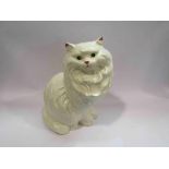 A large ceramic cat and four smaller figures,