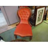 A Victorian walnut buttoned spoon back armchair over a serpentine front seat on turned legs and