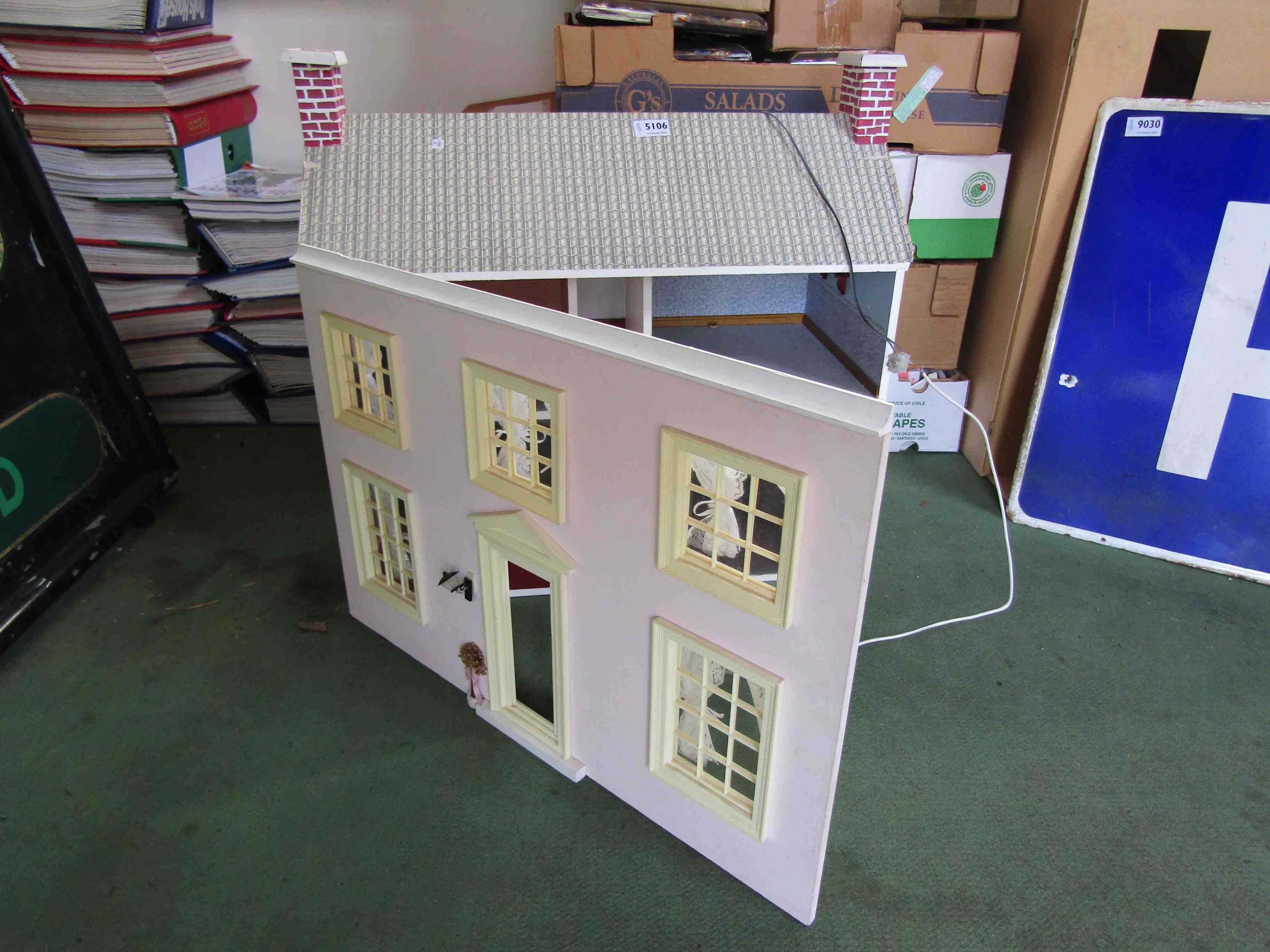 A two storey dolls house with fitted electrical lights,