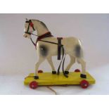 A 1940's East German pull along painted wooden horse,