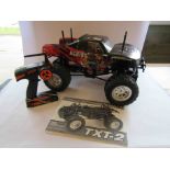 A Tamiya kit built 1:10 scale radio controlled TXT-2 monster truck with Fly Sky remote control,