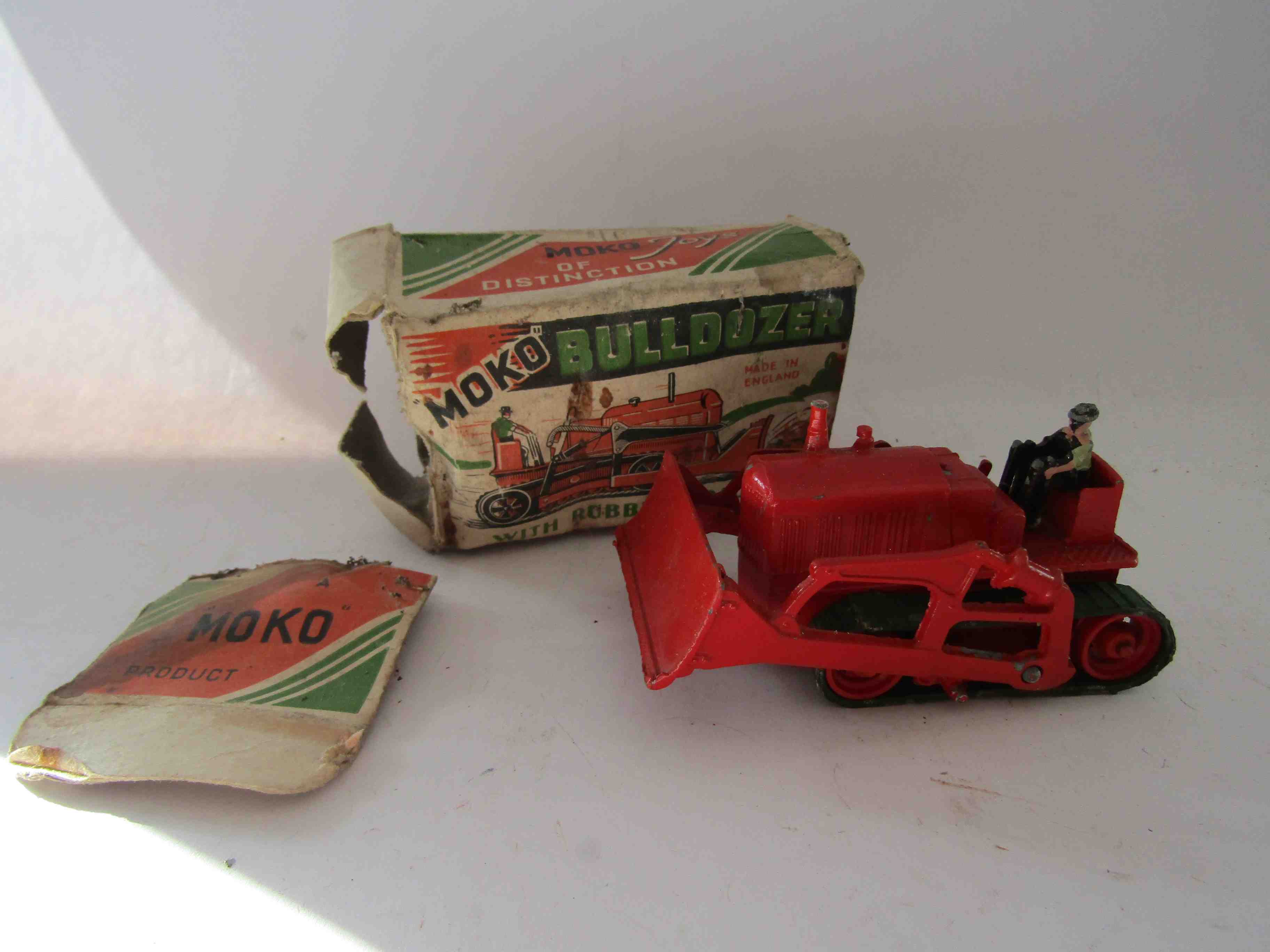 A boxed Moko Toys diecast bulldozer, finished in red with green rubber tracks, with driver,
