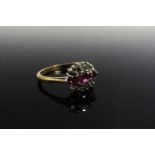 A 9ct gold ring set with three rubies enclosed by six individually set diamonds. Size O/P, 2.