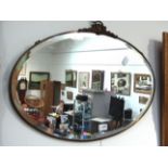 An oval metal framed wall mirror