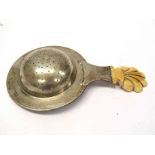 An 18th/19th Century white metal tea strainer with ivory shaped handle,
