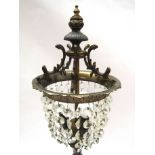 A late 19th/early 20th Century French bronze cherub form figural table lamp with crystal drop shade