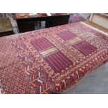 An Eastern wool rug, red ground, two central geometric guls, multiple geometric borders,