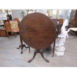 A George III mahogany revolving circular tilt top wine table on a cannon barrel column and tripod