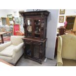 A pair of Victorian carved oak glazed bookcases with lion mask, bust and cherub detail,