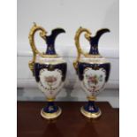 A pair of Coalport porcelain ewers, white ground with cobalt blue panels and floral sprays,