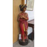 A large carved female figure, semi-clad,