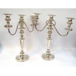 A pair of silver plate three sconce candlesticks, slightly bent,