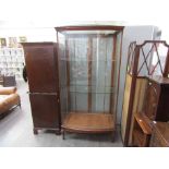 A Victorian full height shop display cabinet, bowed front with adjustable shelved interior,