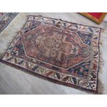 An Eastern wool rug, blue ground central terracotta medallion, cream geometric border, fringing,