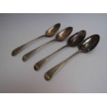 Three George III silver serving spoons with crested handles,