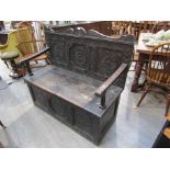 A Victorian oak settle with carved panel back,