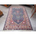 An Eastern wool rug, blue ground central motif of flowers featuring birds and deer, floral border,