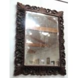 A carved oak rectangular hall mirror with acanthus and scroll detail,