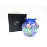 An Okra glass vase designed by Dave Barras, blue with iridescent floral detail.