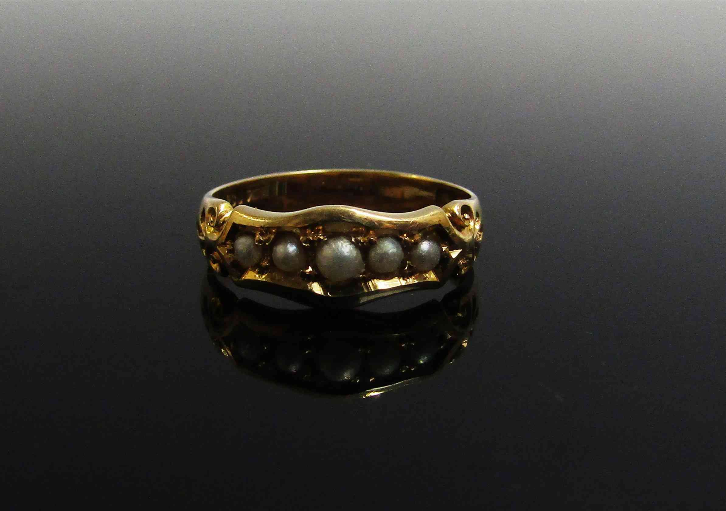 An 18ct gold ring set with five pearls in ornate setting. Size N, 3.
