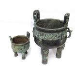 Two Chinese bronze ritual bronze tripod food vessels in the Shang dynasty style,