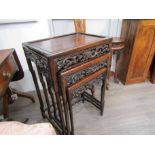 A late 19th Century Chinese hardwood nest of three coffee tables with pierced dragon frieze,
