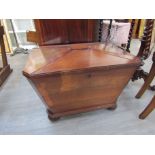 A Regency flame mahogany cellarette of sarcophagus form, bun feet, no liner,