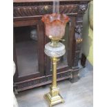 A Victorian brass oil lamp with frilled shade, brass column to pedestal base,